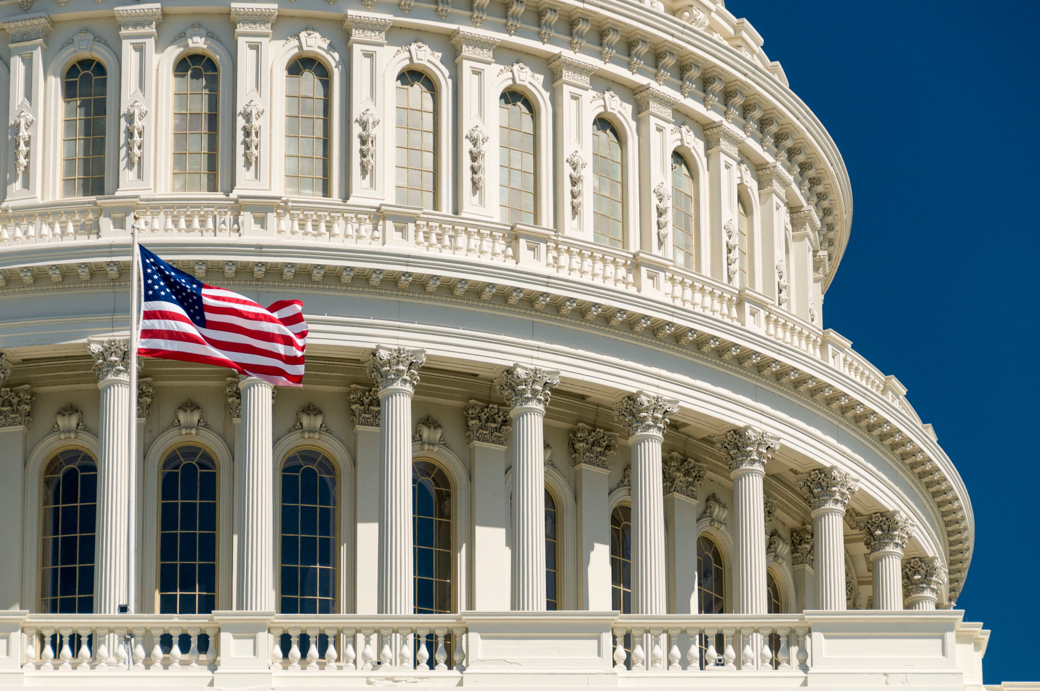 Close-up of the United States Capitol building with an American flag.